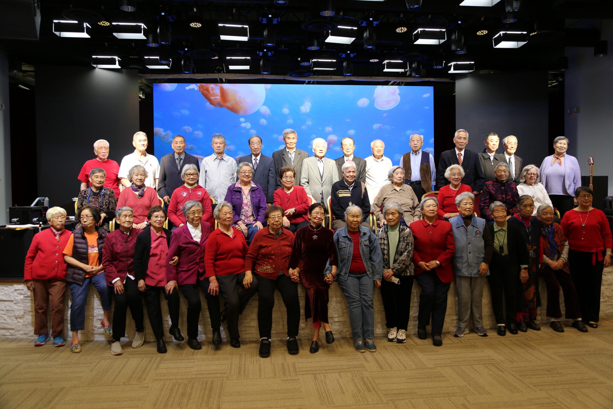 Seniors posing together on stage for a group photo at Le Yuan